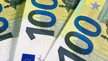 The single currency of the European Union. Three hundred euro banknotes, close-up. One hundred euro bills. Green background of money. European currency. Cash banknotes. 100 euros.