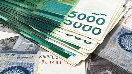 Several 5000 SOM bills are on top of 1000 som bills. Close-up. Kyrgyz national currency. Cash...