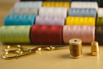 pink, orange, yellow, red, brown, green, blue, lilac, white sewing thread on spools, scissors,...