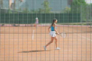 Abstract blurred background, girl playing tennis outdoors. Concept of sport
