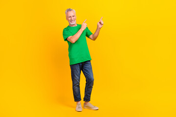 Full body photo of positive person indicate fingers empty space advert blank information isolated on yellow color background