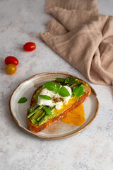 Toasted sourdough bread with grilled asparagus, avocado, poached egg and herbs for single serving. Avocado toast. Breakfast idea. Healthy food concept.