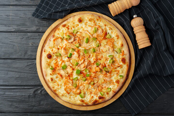 Fresh tasty pizza on black wooden background