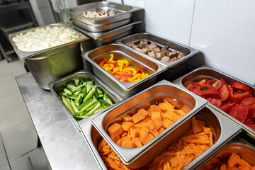 Stainless steel food trays on counter in professional kitchen