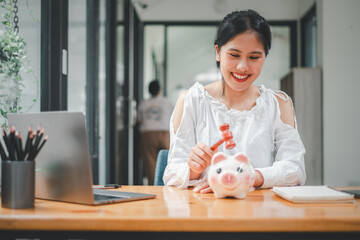 Woman hand holding a hammer which is raised above a piggy bank, with a shocked and apprehensive...