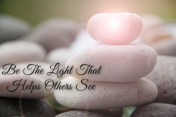 Motivational and inspirational quote - Be the light that helps others see text with zen stones background. Inspirational concept.