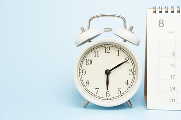 close up of calendar and alarm clock on the blue table background, planning for business meeting or...