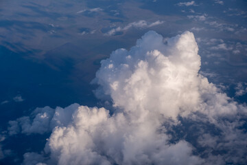 Big white clouds in a blue sky close-up. View of the clouds from the sky, and under the clouds the earth. There is a place for the text. The concept of cleanliness in nature and caring for nature