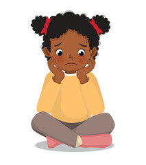 Sad little African girl sitting on the floor with her chin resting on her hands