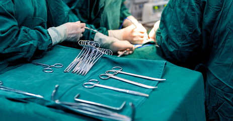 Surgeons are operating with nurse preparing medical instruments