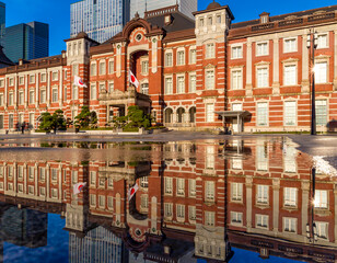 Reflection of the 1800s era red brick Tokyo Station building in water sprayed to cool the outside...