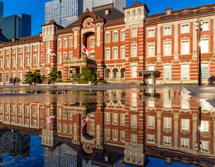Beautiful reflection of the red brick Tokyo Station in water sprayed to cool the path in the middle of summer