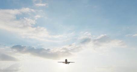 Fototapeta premium Airplane in the sky at sunset. Air transportation. Travel. Airplane Takes Off Against the Background of Blue Sky. 