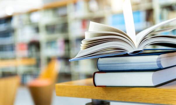 Stack of books opened on library desk
