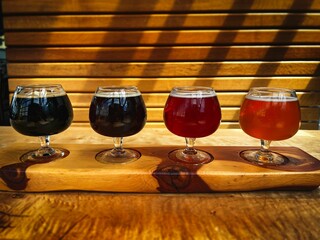 Close-up of  four colorful beers on a wooden paddle on a sunny day