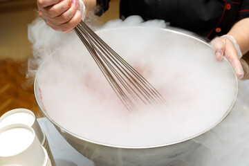 Stirring ice cream frozen with liquid nitrogen in a large cup.