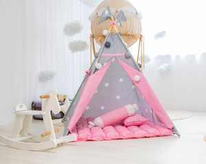 Playroom with Teepee. Modern room interior with play tent for child. pink children's wigwam in the room on the floor Scandinavian style with decor. High quality photo © Nataliia