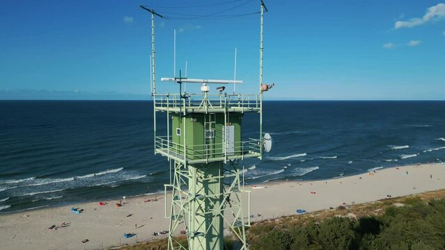 border observation tower with radar and antenna, sea shore with beach, 4k aerial