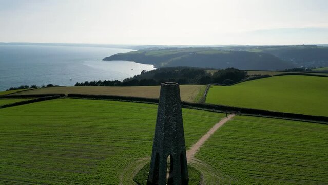 Aerial of the Daymark tower in Kingswear, England standing in the middle of a green field