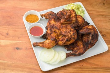 the grilled chicken is ready to be eaten with dipping sauce on a white plate