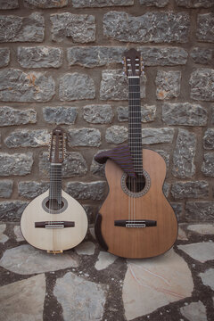Spanish guitar and bandurria leaning against a stone wall with a "cachirulo".