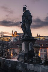 Fototapeta na wymiar Statue on Charles Bridge with a castle in the background