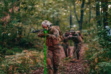 Naklejka premium A group of modern warfare soldiers is fighting a war in dangerous remote forest areas. A group of soldiers is fighting on the enemy line with modern weapons. The concept of warfare and military