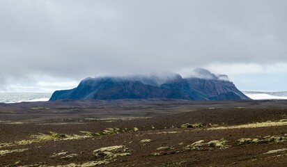 Scenic landscape on a cloudy day featuring a majestic mountain range in fog, Iceland