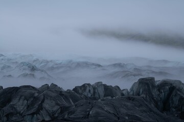 Scenic landscape on a cloudy day featuring a majestic mountain range in fog, Iceland