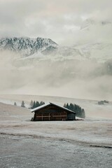 Winter scene featuring a snow-covered landscape with a house in the middle of the frame.