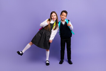 Photo of funny schoolkids enjoy season school discounts make thumb up like isolated bright color...