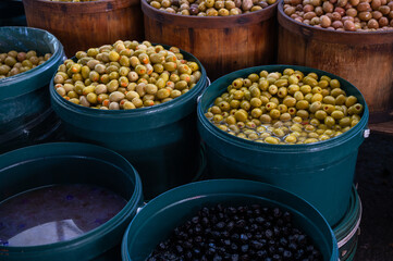 Different olives sale in the traditional farm Turkish market, a counter filled with fresh fruits