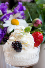 whipped cream in a glass with berries. Sweet dessert with strawberries and blackberries