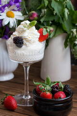 whipped cream in a glass with berries. Sweet dessert with strawberries and blackberries
