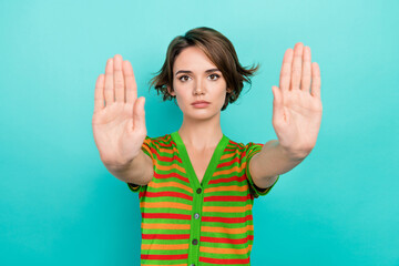 Portrait of serious focused girl arms palms demonstrate stop enough you gesture isolated on turquoise color background