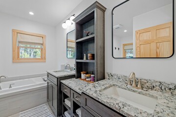 Elegantly designed bathroom interior featuring a large vanity, bathtub and sink