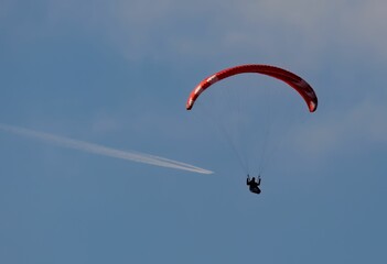 a person on a parasail, going under clouds