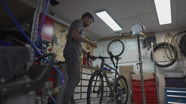 Bike technician twists bike stem and handlebars with special tool. Repairman using tool to fit handlebar bolts. Bicycle service. Bike mechanic at work. Repairing cycles. Workshop. Repair of bicycles. 