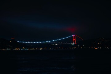 Fototapeta na wymiar Fatih Sultan Mehmed Bridge on a dark night in Istanbul, Turkey, illuminated by the lights