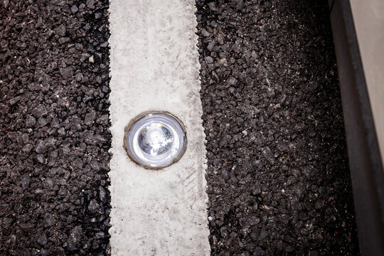 Round glass reflector on the road .  Road reflector for night ride safety. Traffic transport construction maker street safety road by use reflective glass road stud. Glass road stud
