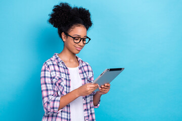 Photo of diligent cheerful girl with perming coiffure dressed checkered shirt look at tablet read...