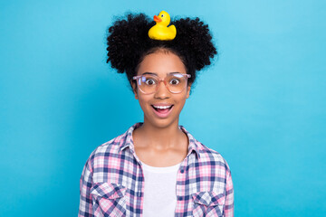 Photo of shocked impressed lady wear plaid shirt spectacles holding head rubber duck isolated blue...
