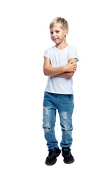 Fototapeta premium Smiling boy stands . A child in jeans and a white T-shirt. Positivity and confidence. Isolated on white background. Vertical.