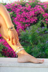 woman relaxing in the pool. Close-up of woman with anklet and bracelet in hand. Fashion and holiday concept.