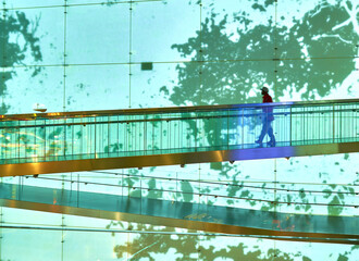 a man walks on a bridge in a museum