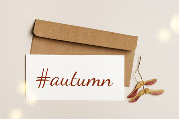 Autumn mood flat lay, Top view white paper card with word hashtag autumn and craft paper...