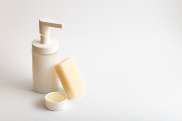 White washing products on white background: liquid soap, bar soap and balm