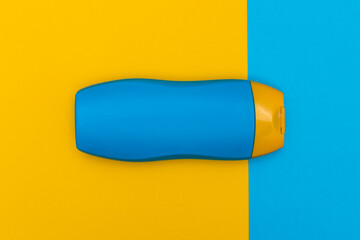 Sunbathing lotion for the summer in a nice colour twist. Combination of contrasting blue and yellow container on background with same colours. Great as background