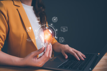 Businesswoman holding light blub with virtual Global Internet connection. Woman use computer to searching for information. Concept of inspiration creative smart thinking and innovation with network.