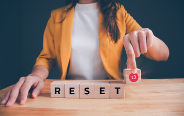 Businesswoman in a yellow suit is picking up wooden blocks with words 